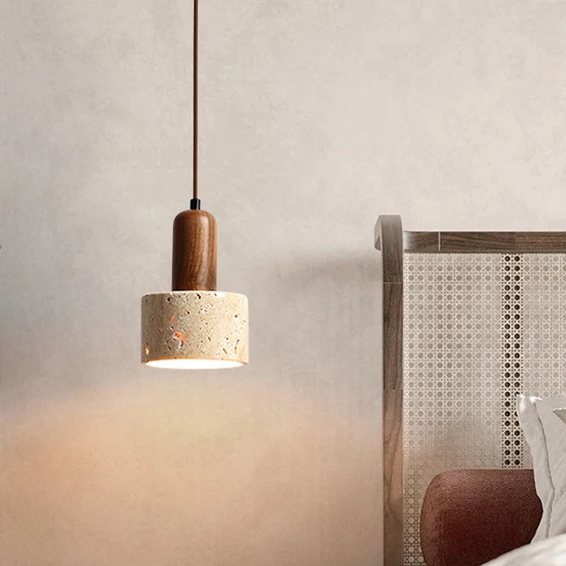Marble cylinder pendant light hanging beside a bed