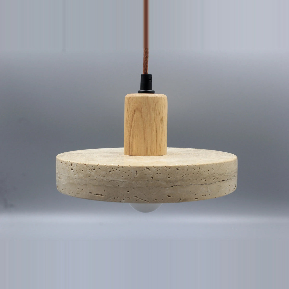 Stone disc pendant light with a light wood-tone top, front view