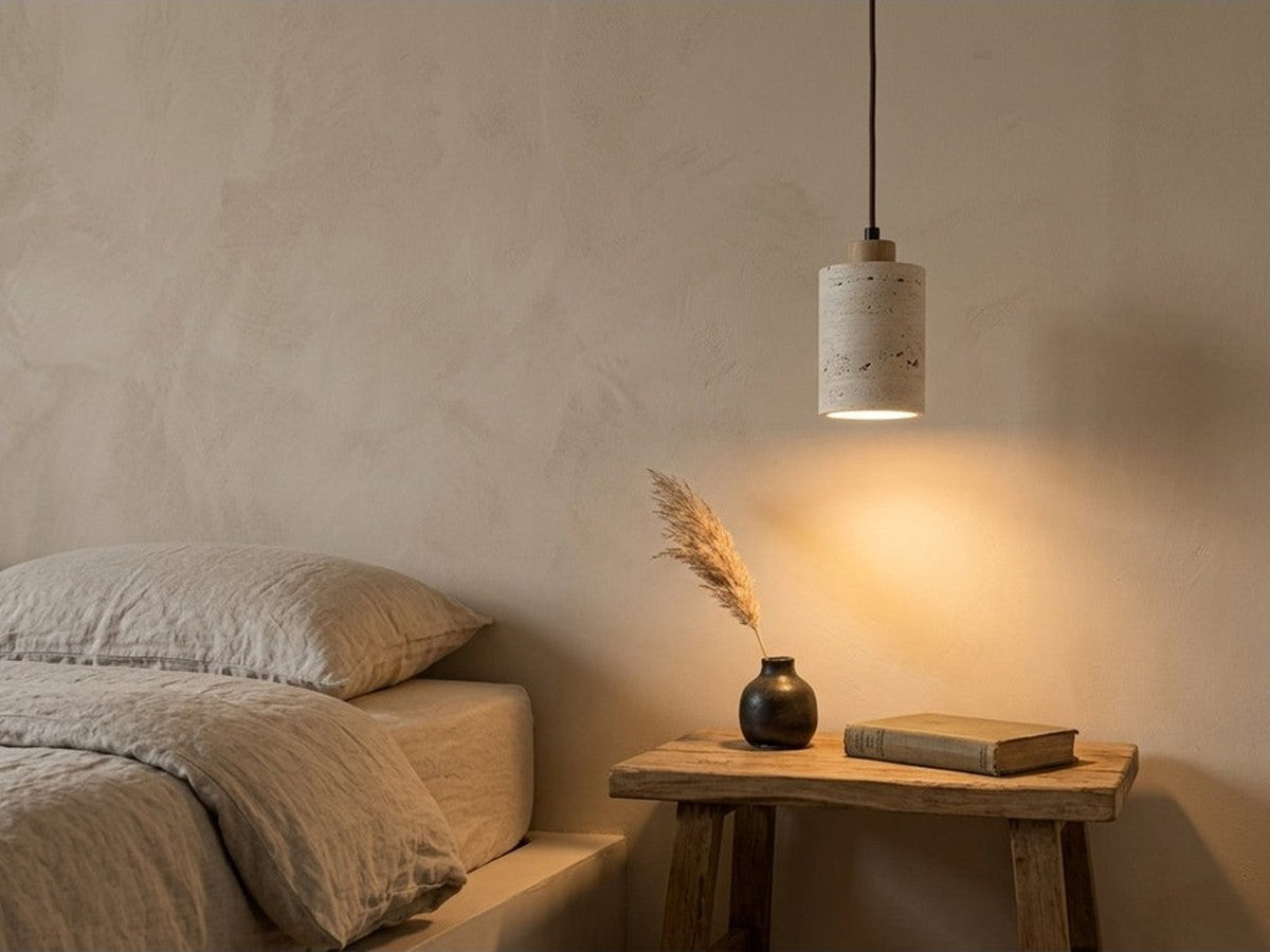 Stone pendant light beside a bed.