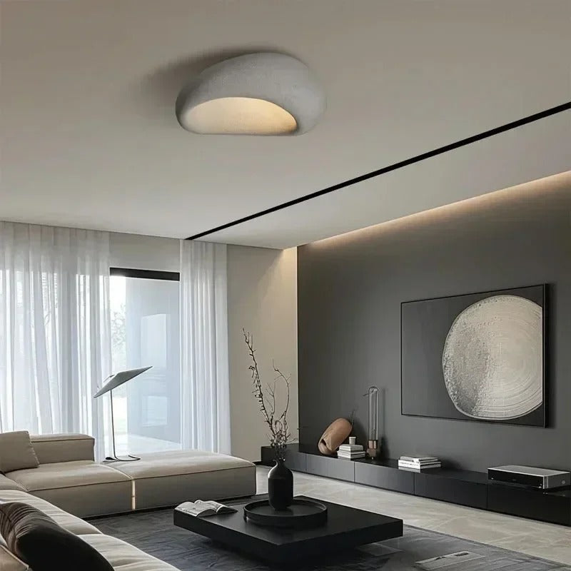White oval ceiling light above a lounge with a television
