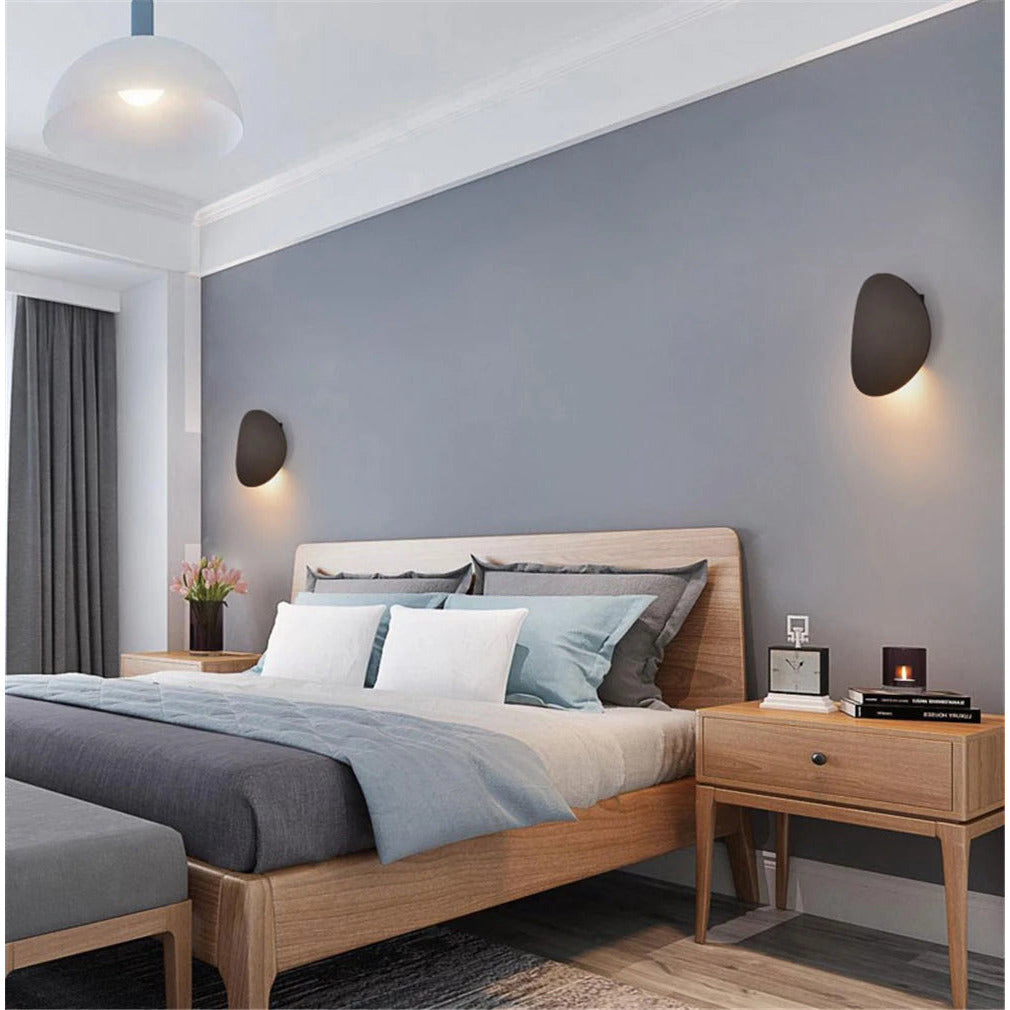 Round wall light shown in a bedroom setting