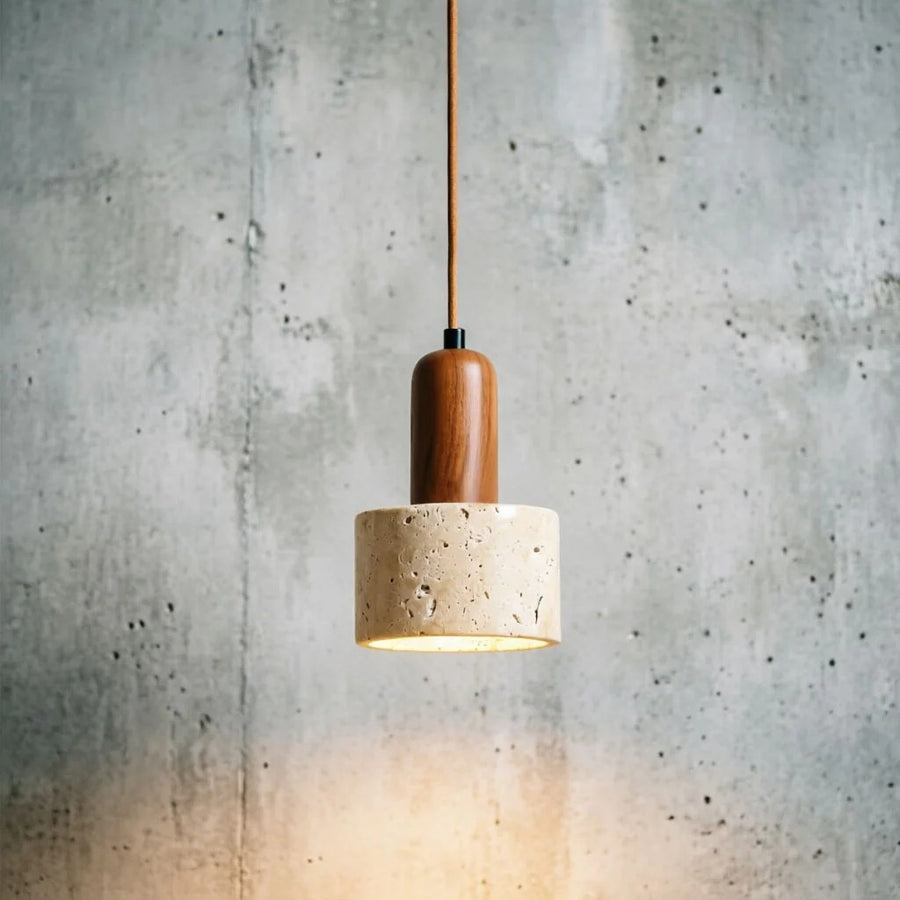 Marble cylinder pendant light switched on against a grey wall