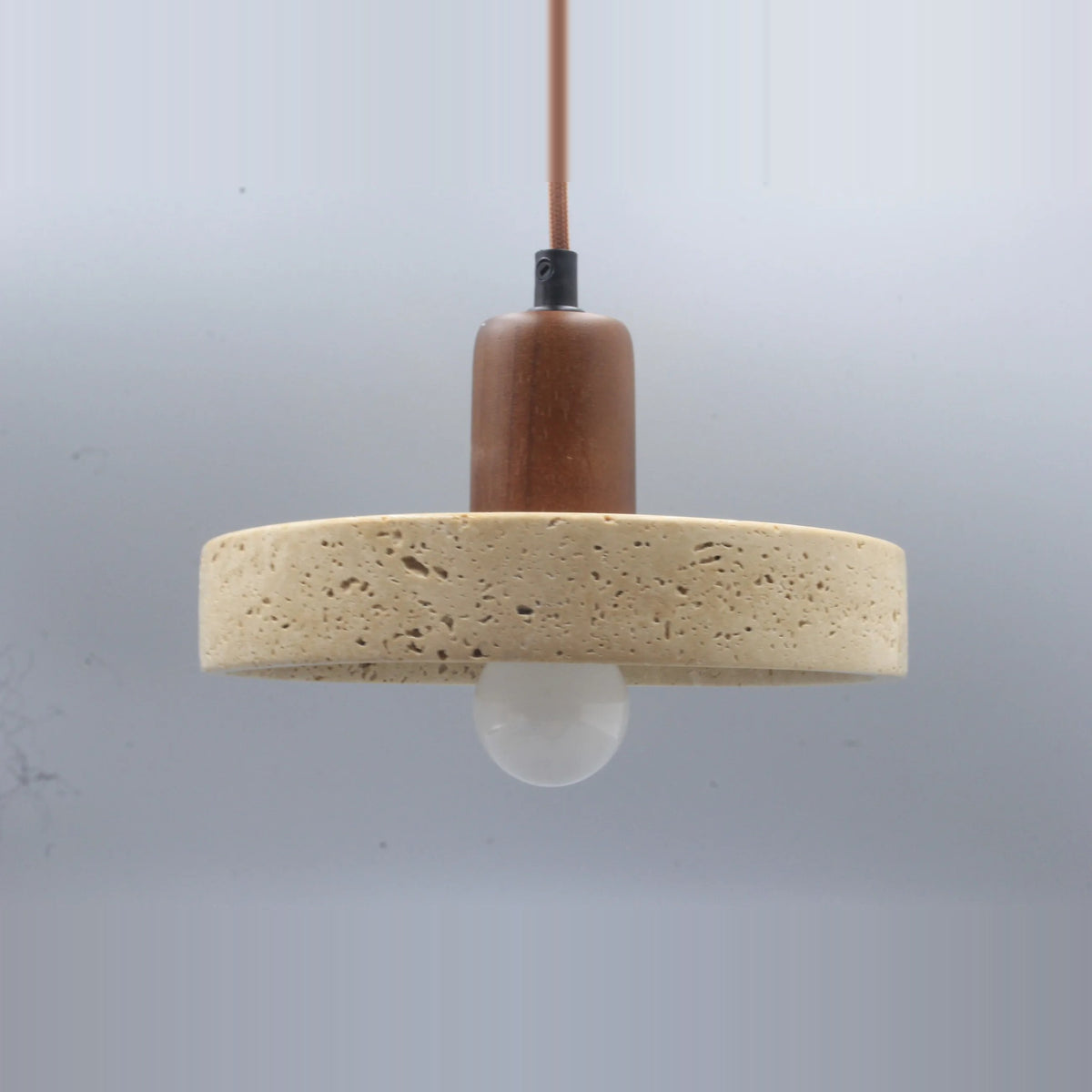 Side view of the stone disc pendant light with a walnut-tone top