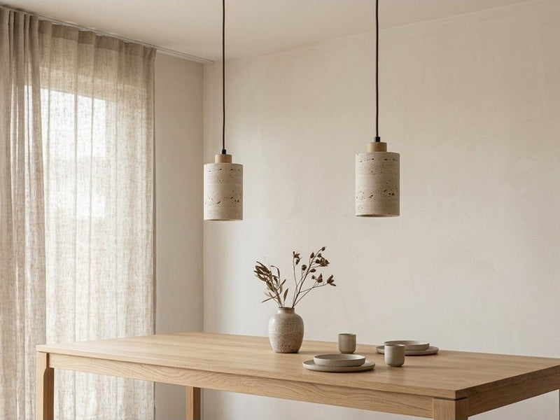 Two stone pendant lights above a dining table.