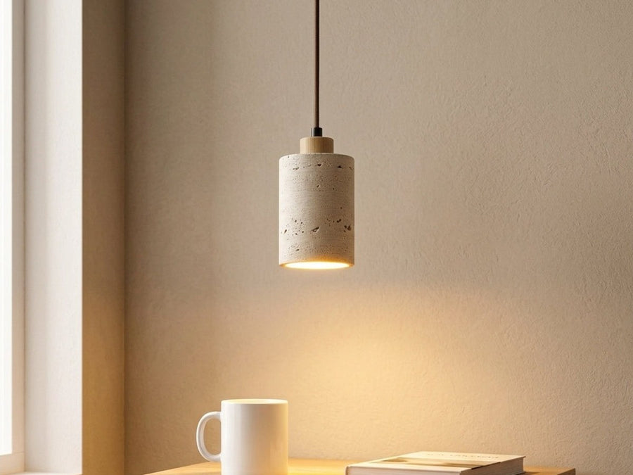 Single stone pendant light beside a bedside table.