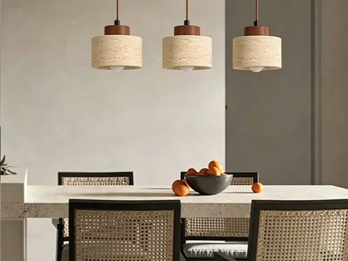Three stone pendant lights above a dining table.