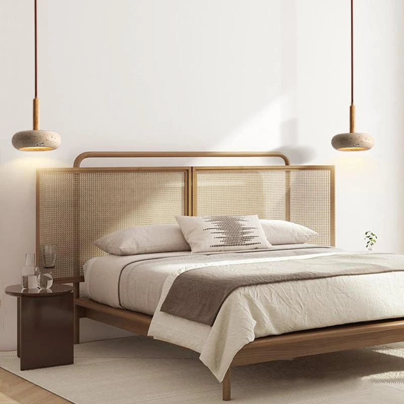 Two travertine disc pendant lights either side of a bed