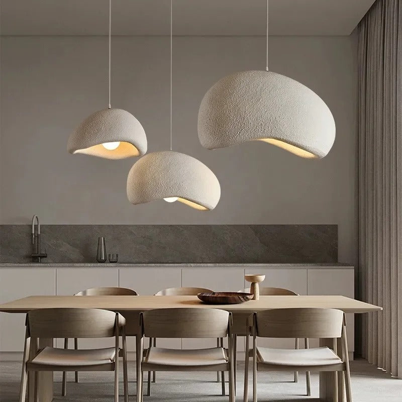 Three white dome pendant lights above a wooden table